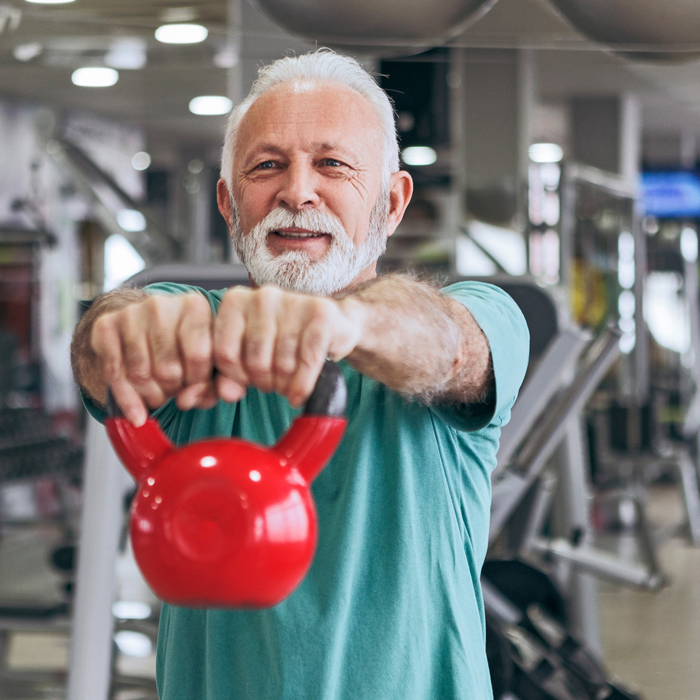 Man lifting up kettlebell at the gym